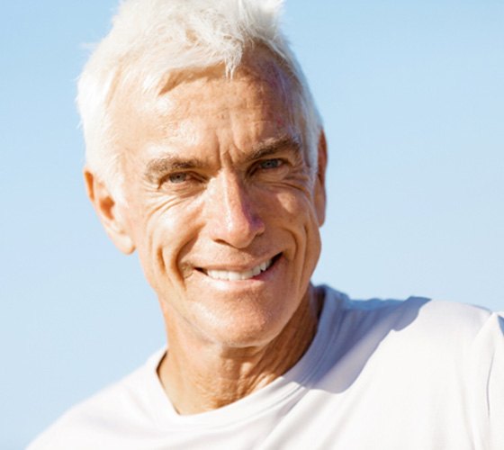 Senior man in white shirt smiling in the sun