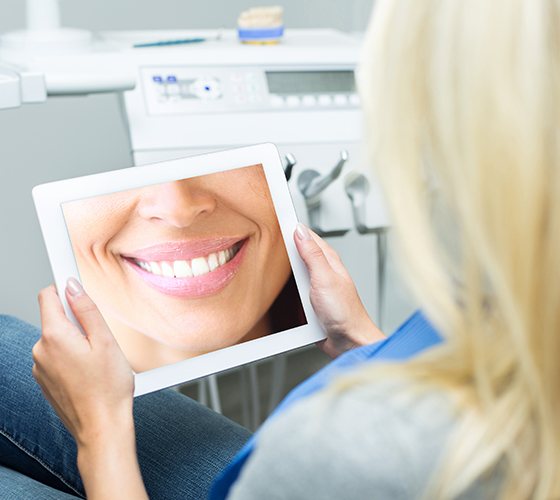 Woman looking looking at digital smile design on tablet computer