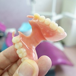 A close-up of a hand holding a denture