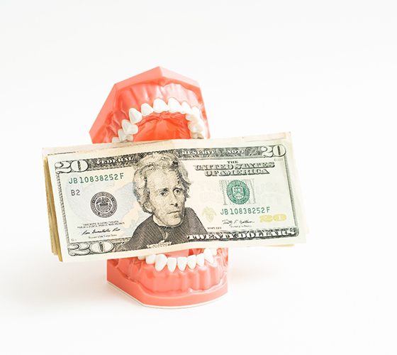 Dentures holding money representing the cost of dentures in Lady lake