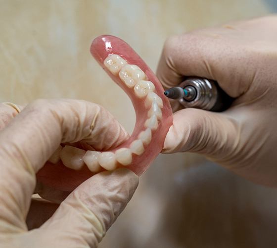 Dental technician polishing a denture