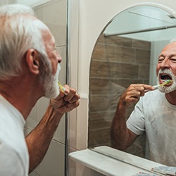 Man brushing his teeth after dental implant surgery in Lady Lake 