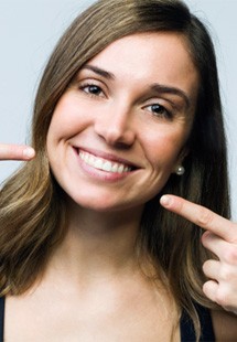 Woman smiling and pointing to her teeth