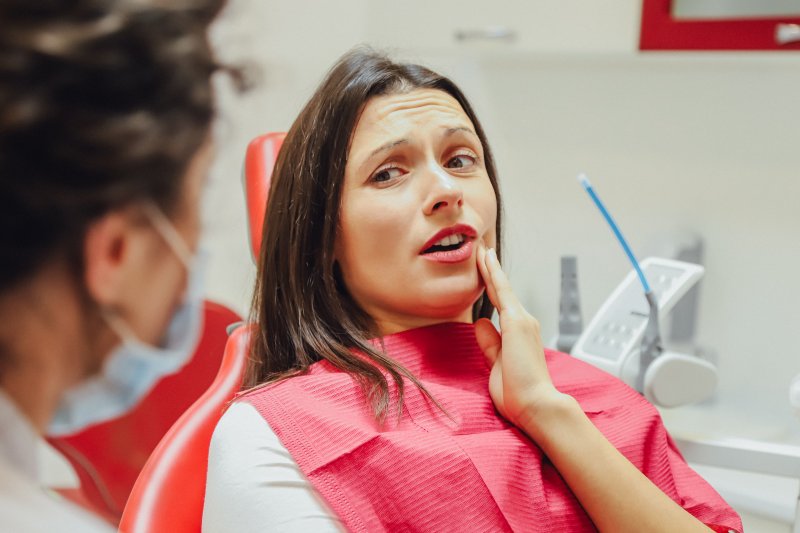 Dentist explaining dangers of getting dental implants for cheap