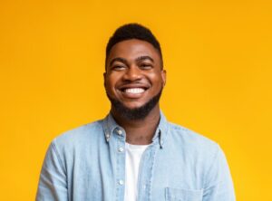 man smiling with a brilliant smile against a yellow background